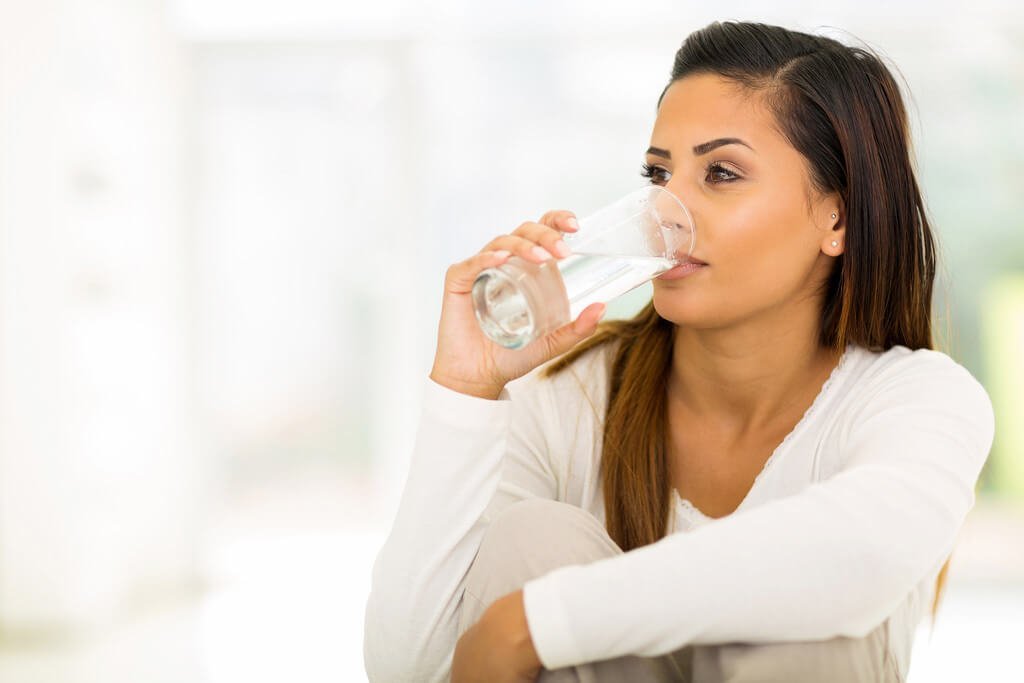 Woman Drinking A Glass of Water - Drink Plenty for Younger Looking Skin