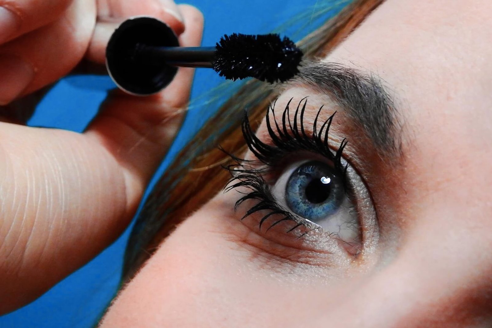 close up of woman applying mascara to lashes